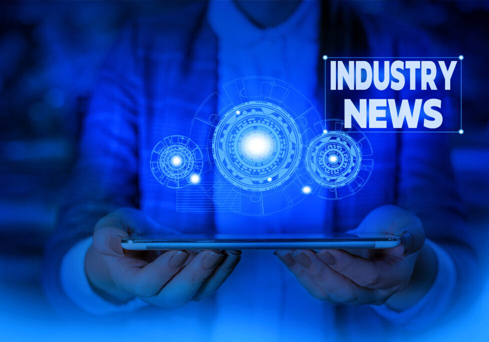 Industry News graphic with a person holding a tablet and glowing digital icons, representing 2026 ghostwriting and publishing trends